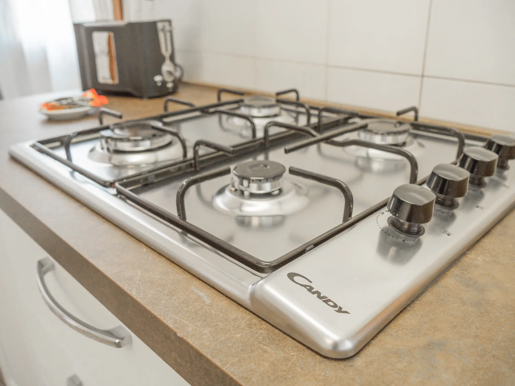 A kitchen stovetop with several gas burners and control knobs.