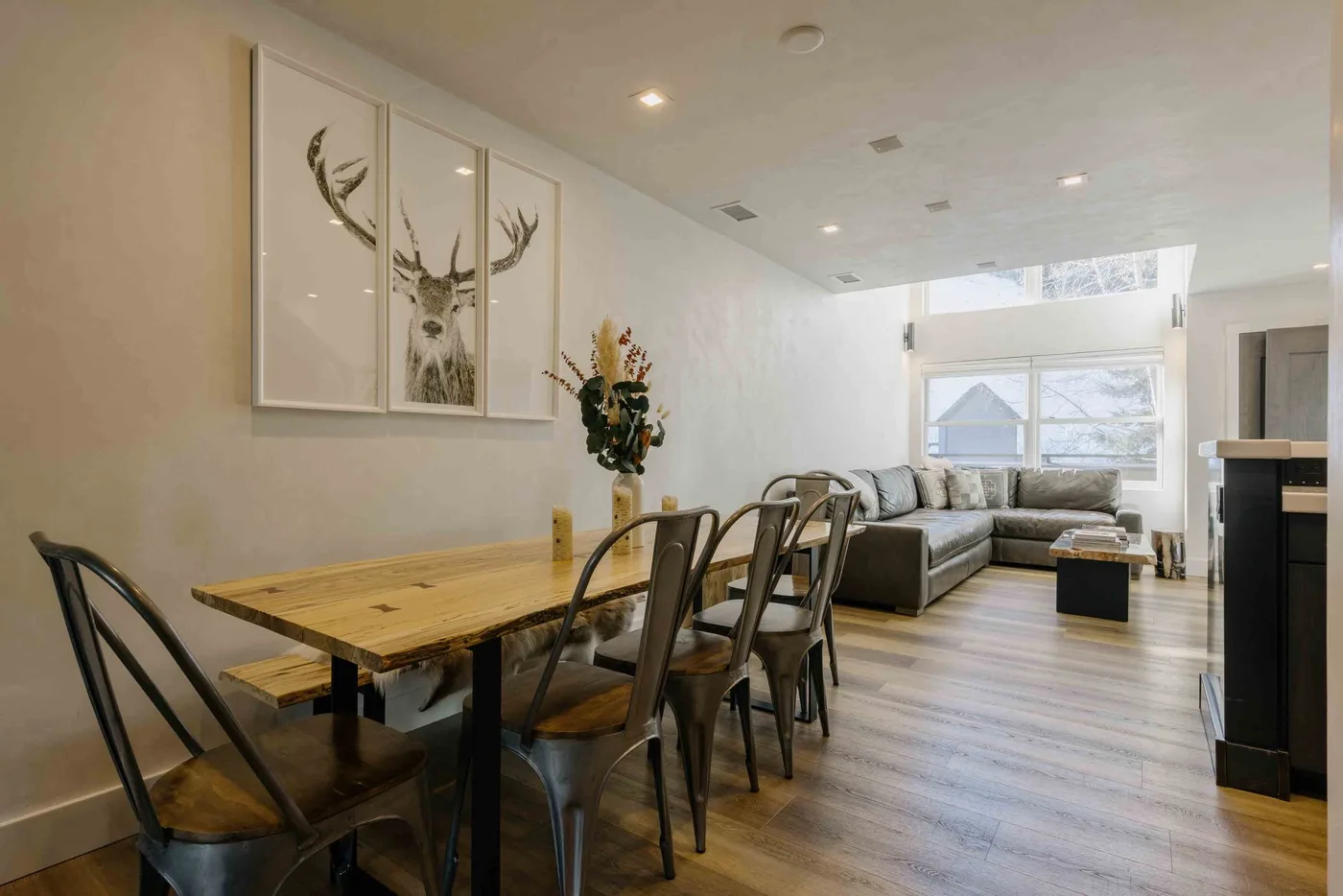 Una sala-comedor abierta con una mesa de madera y asientos seccionales.