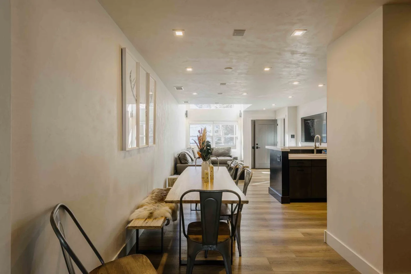 Un comedor con una mesa larga se abre a una cocina.