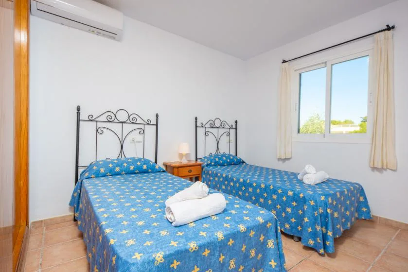 A bedroom with two beds covered in blue patterned bedding.