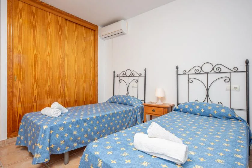 A bedroom with two beds covered in blue patterned bedding.