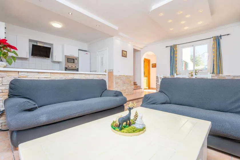 A bright living room with blue seating and a white coffee table.