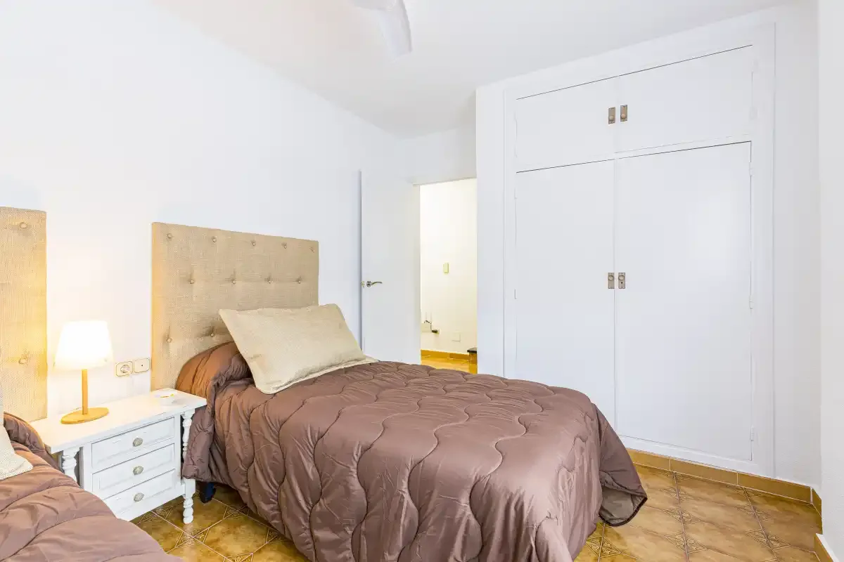 A bedroom with a double bed and built-in storage.