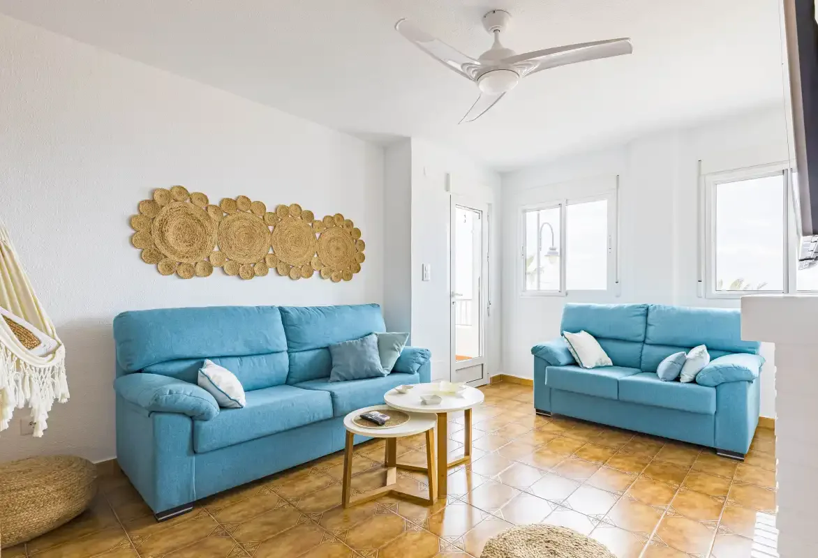 A bright living room with blue seating and a small coffee table.