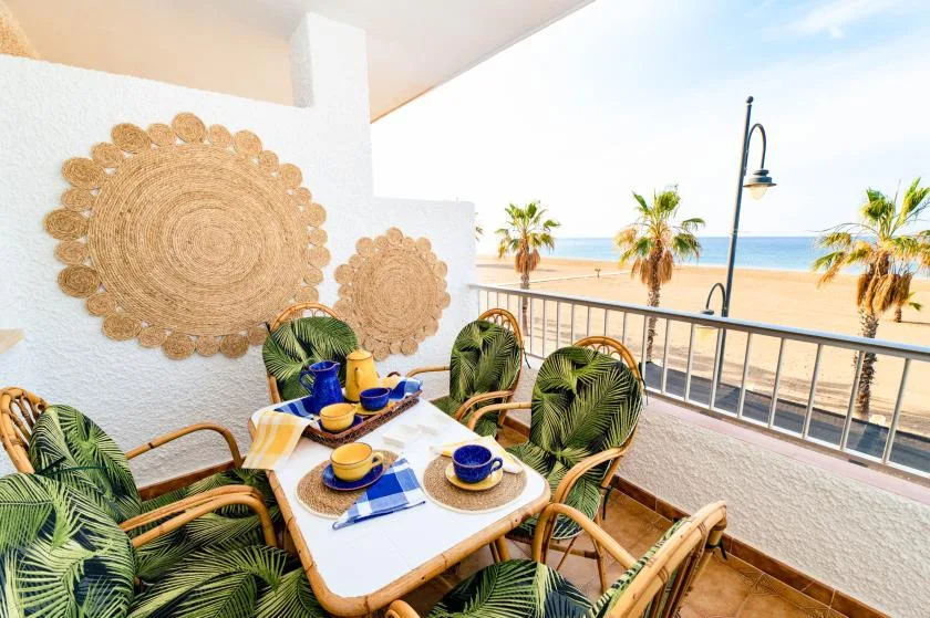 A balcony dining area overlooks the beach and ocean.
