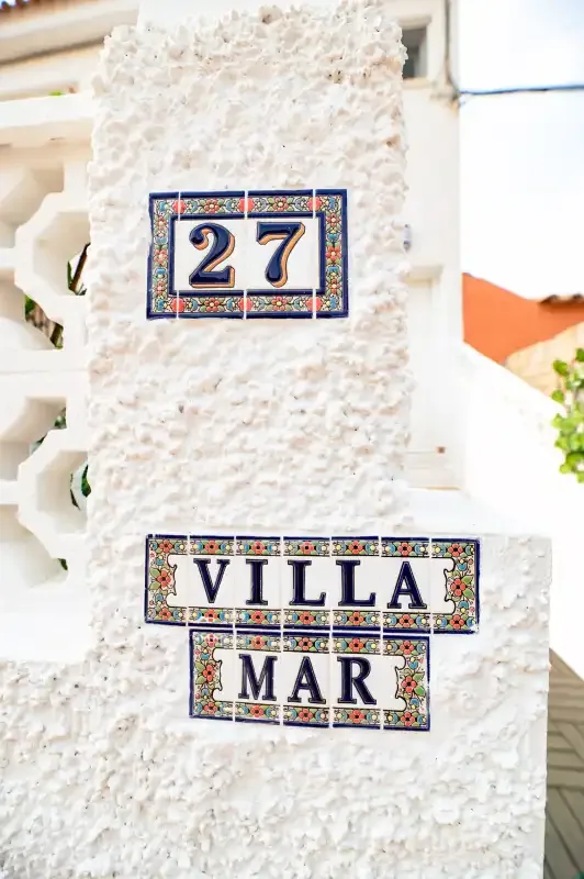 Decorative tiled signs reading “27” and “Villa Mar” are mounted on a white wall.