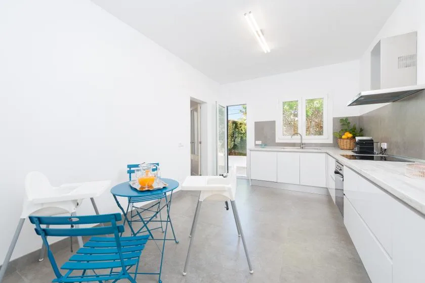 A bright kitchen and dining area with white cabinetry and a small table.