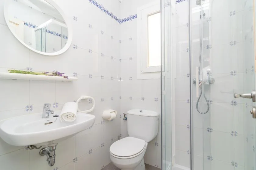 A bright bathroom with a sink, toilet, and glass shower.