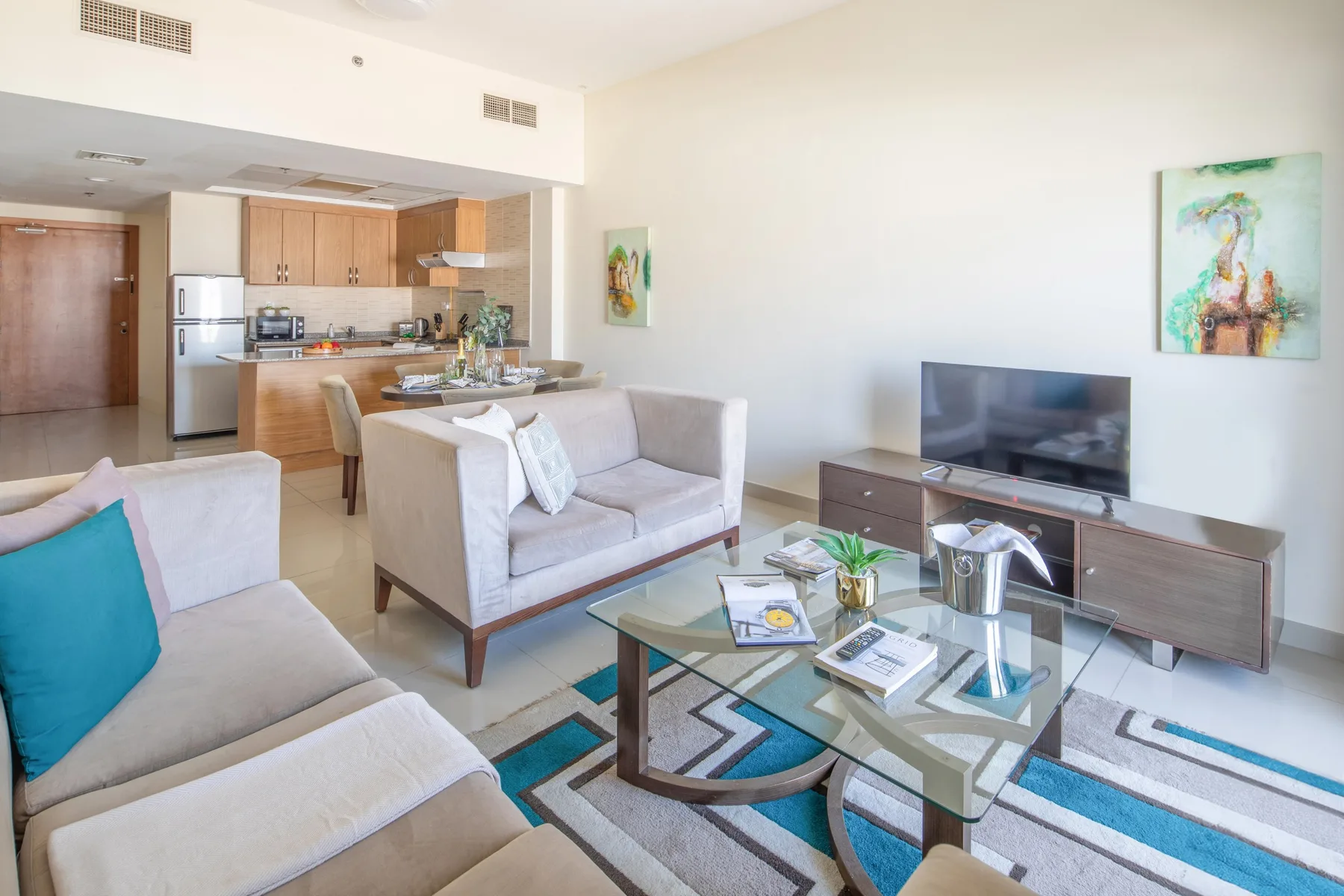 Sala de estar con una zona de comedor y cocina al fondo.