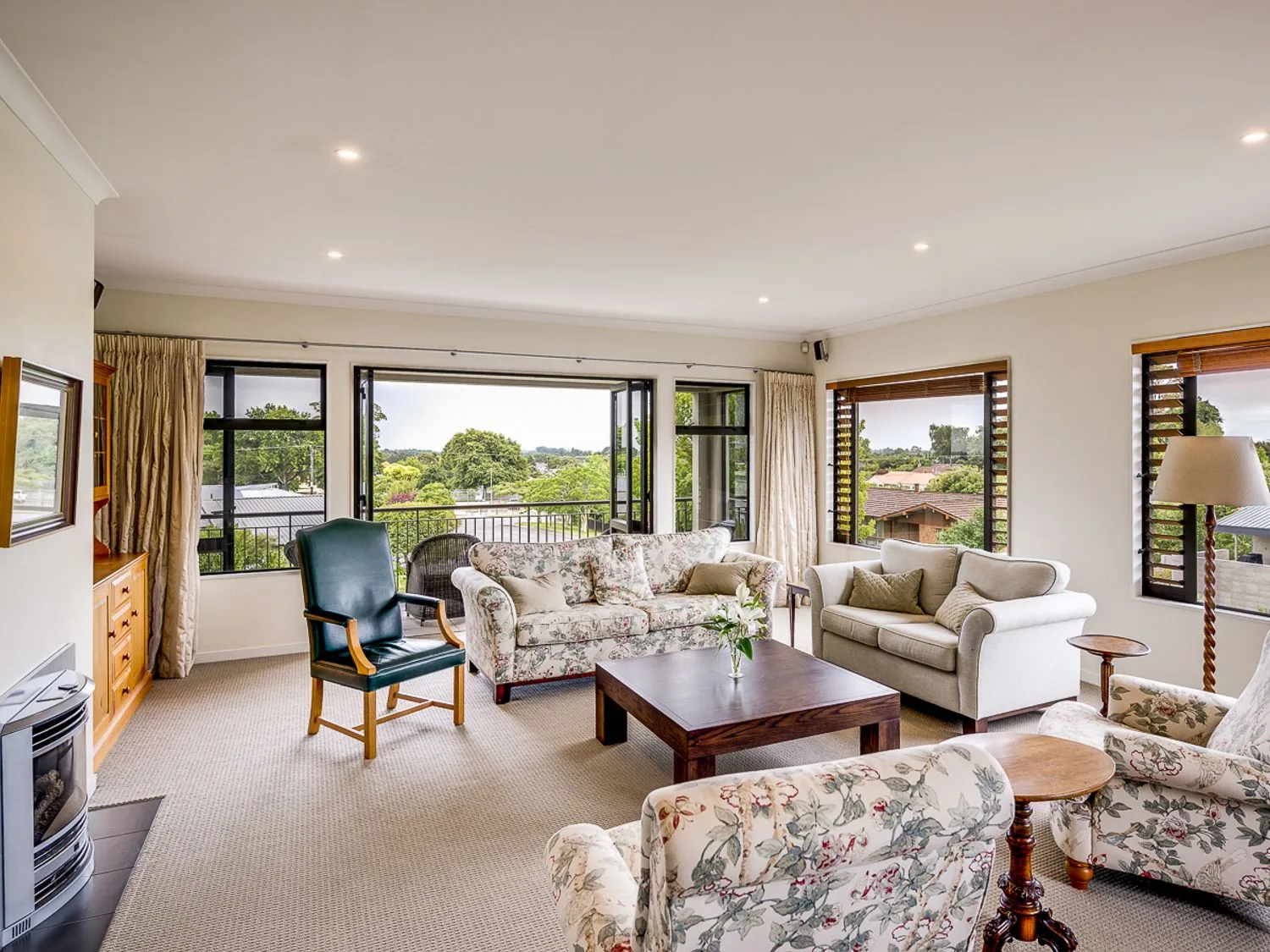 A living room with sofas armchairs coffee table and a lamp at Busby Hill Villa - Havelock North Holiday Home in Havelock North