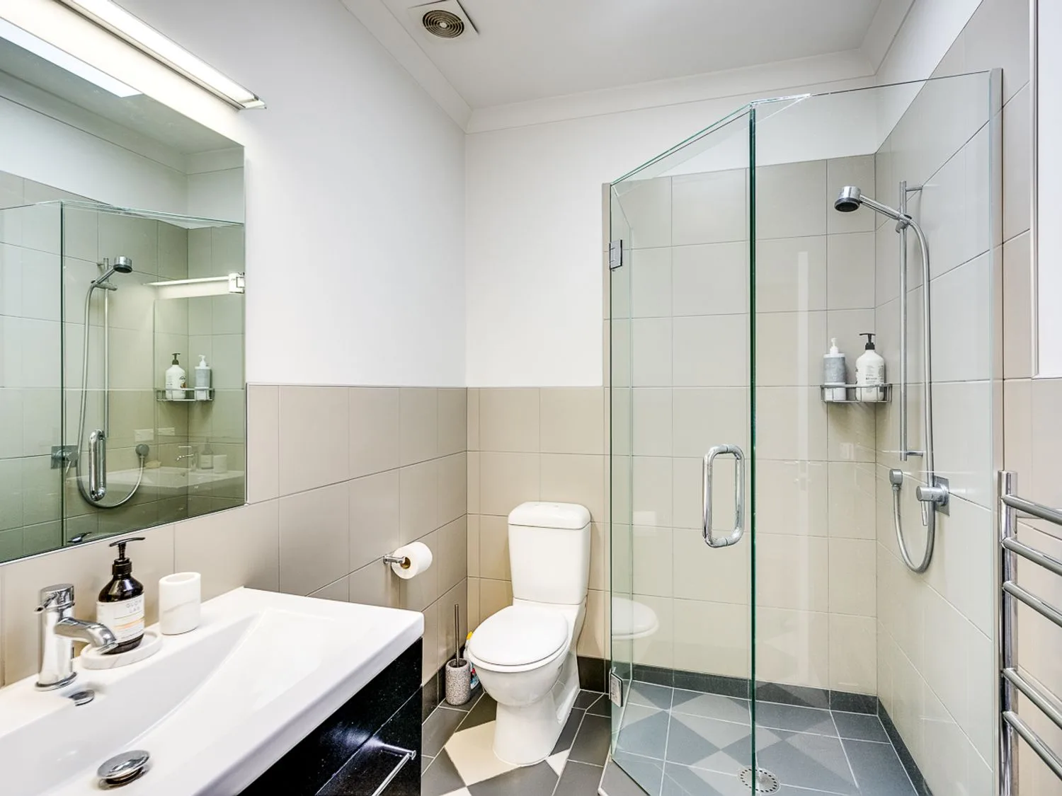 A bathroom with a sink, toilet, and glass shower.