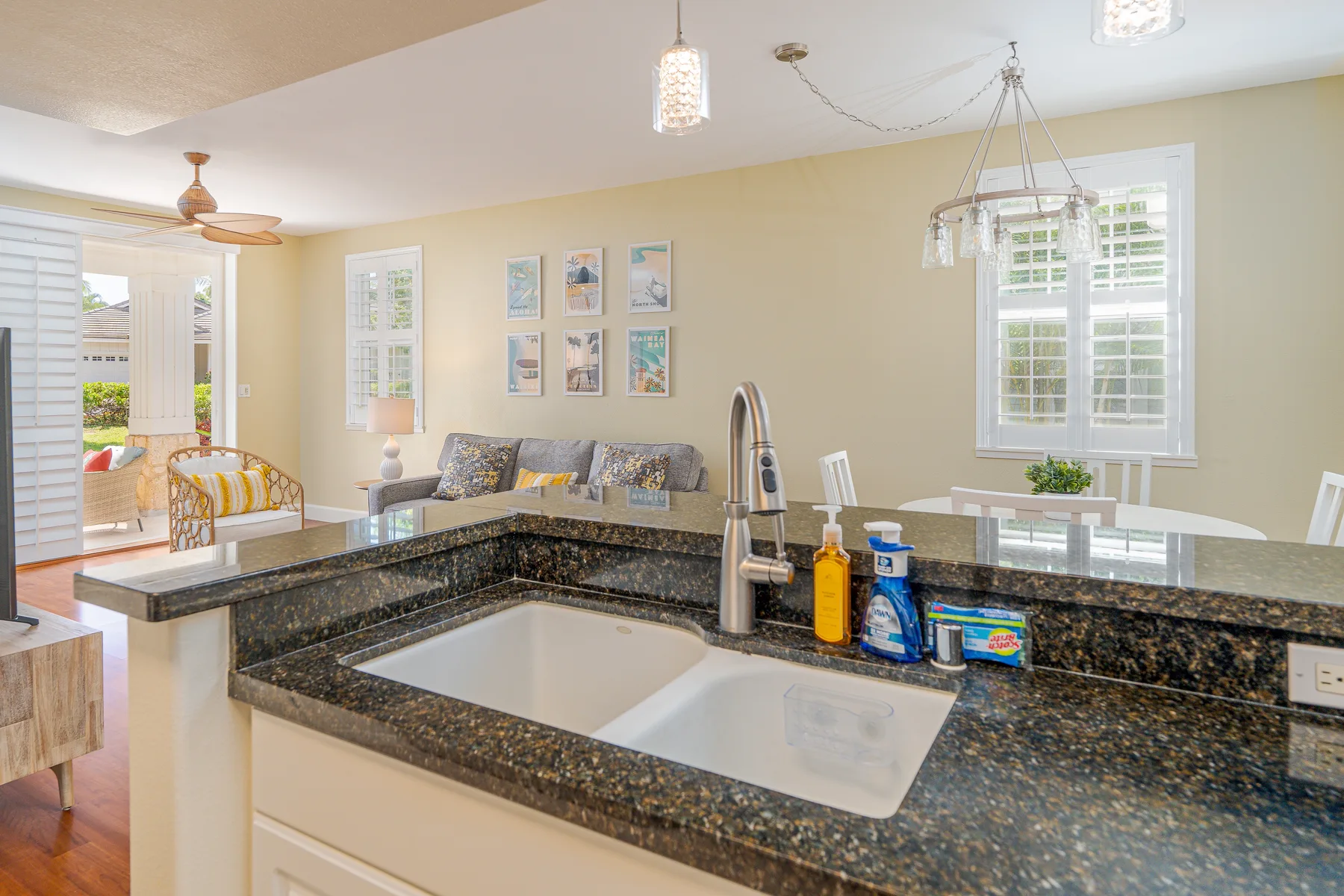 A bright kitchen with a large island and an open sitting area beyond.