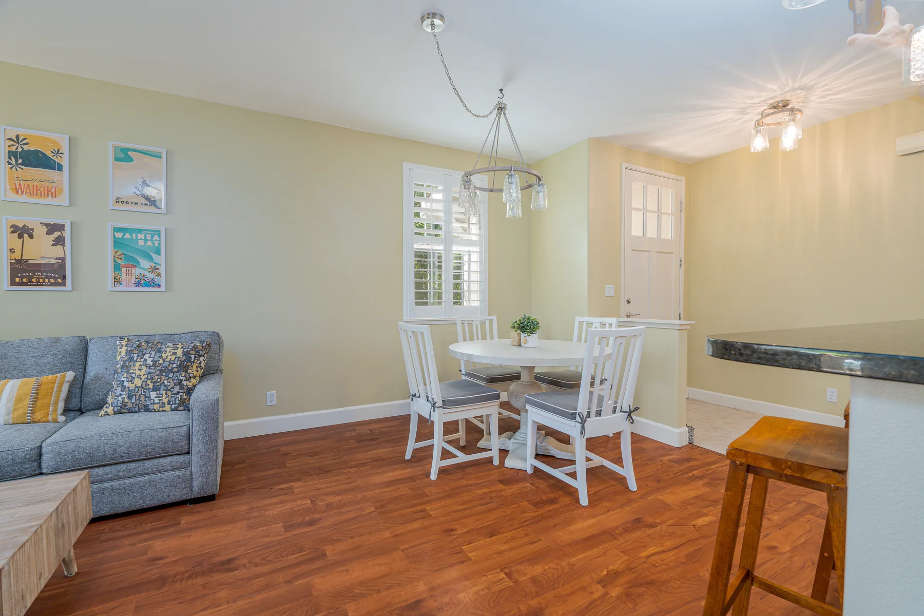 A dining area with a table and chairs beside a living room seating area.