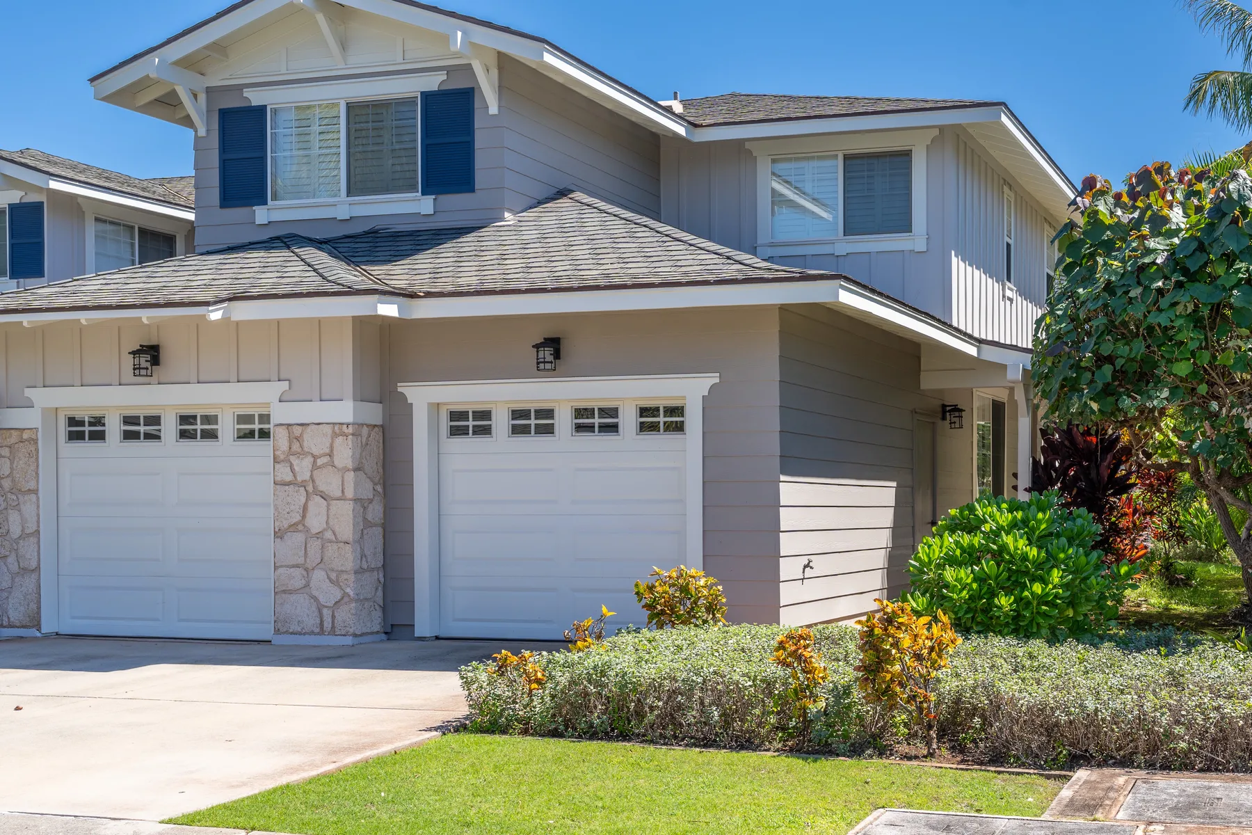 A two-story suburban house with attached garages and a landscaped front yard.
