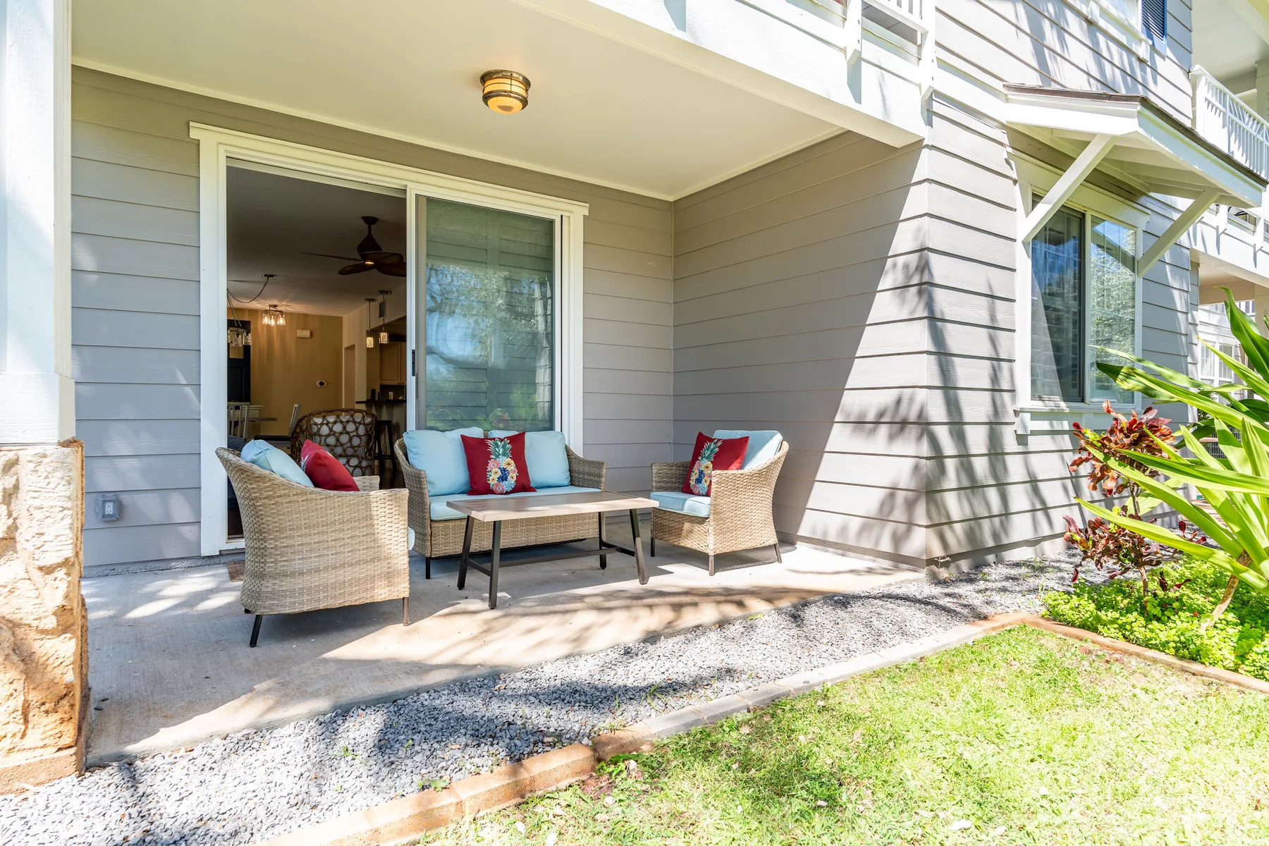 An outdoor patio with cushioned seating and a sliding glass door.