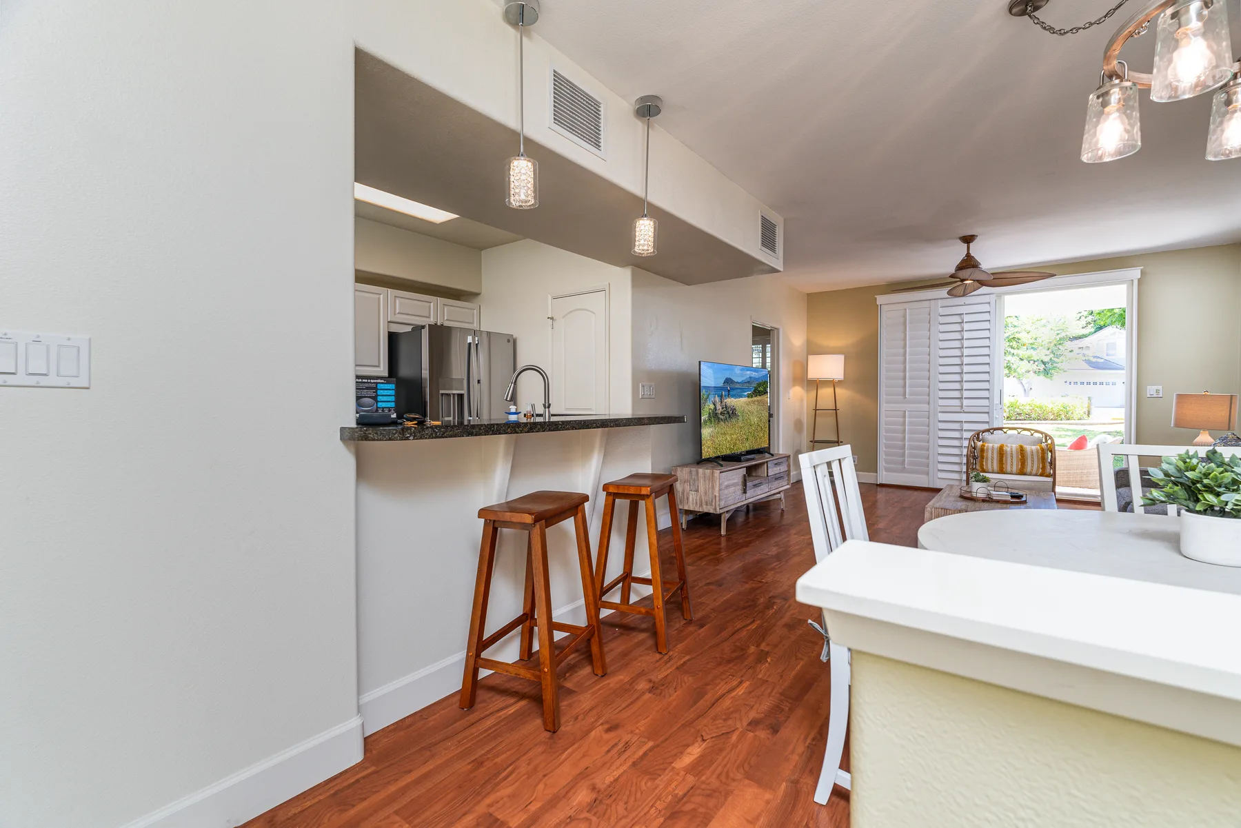 An open-plan kitchen and living area with a breakfast counter and dining table.