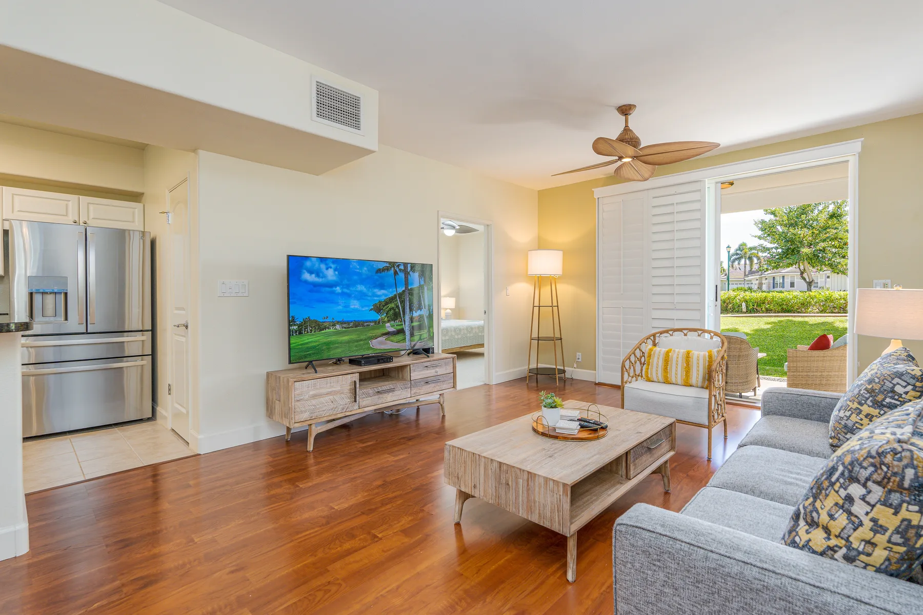 A living room with seating, a television, and sliding glass doors opening to a patio.