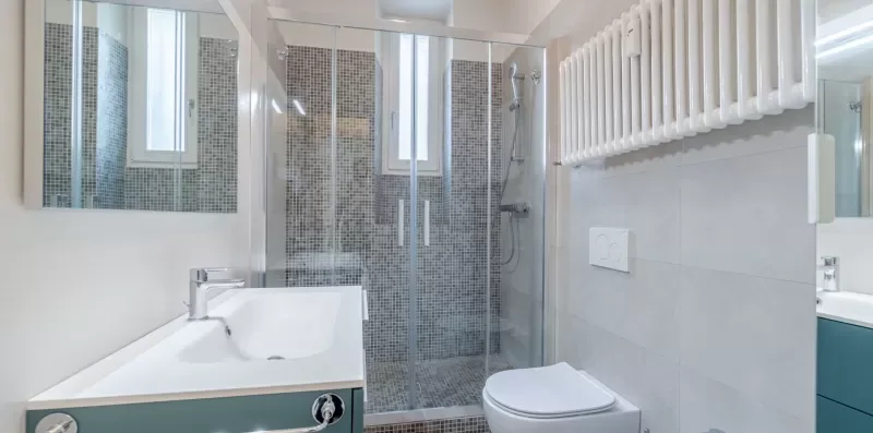 A bright bathroom with a sink, toilet, and glass shower.