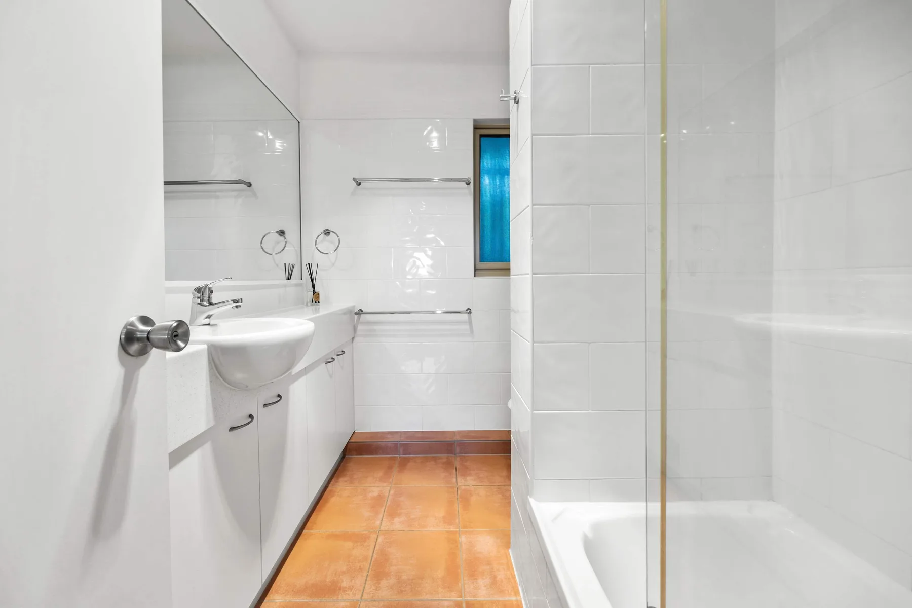 Un baño con azulejos, lavabo y ducha.