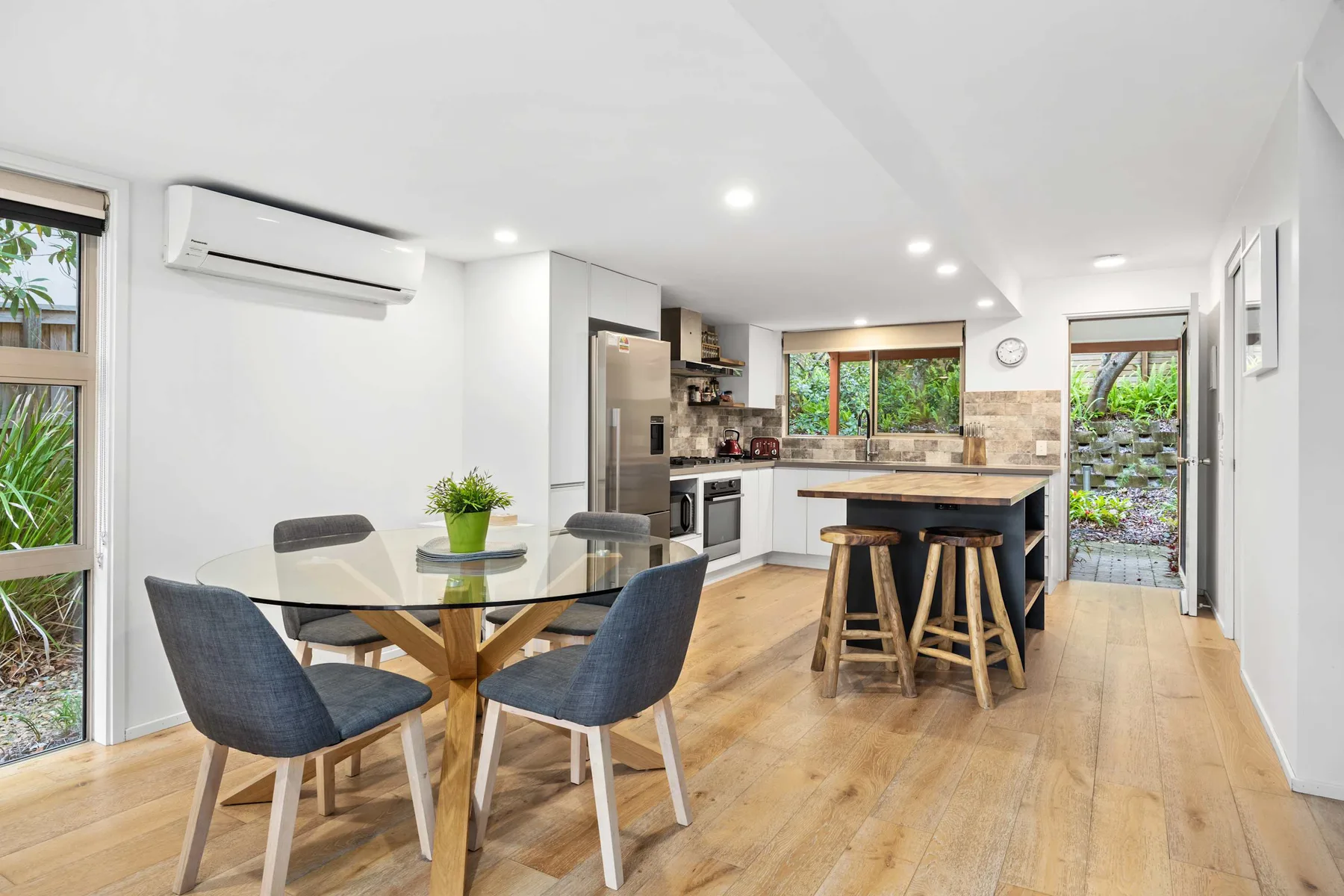 Cocina y comedor de planta abierta con una isla central y una mesa de comedor.
