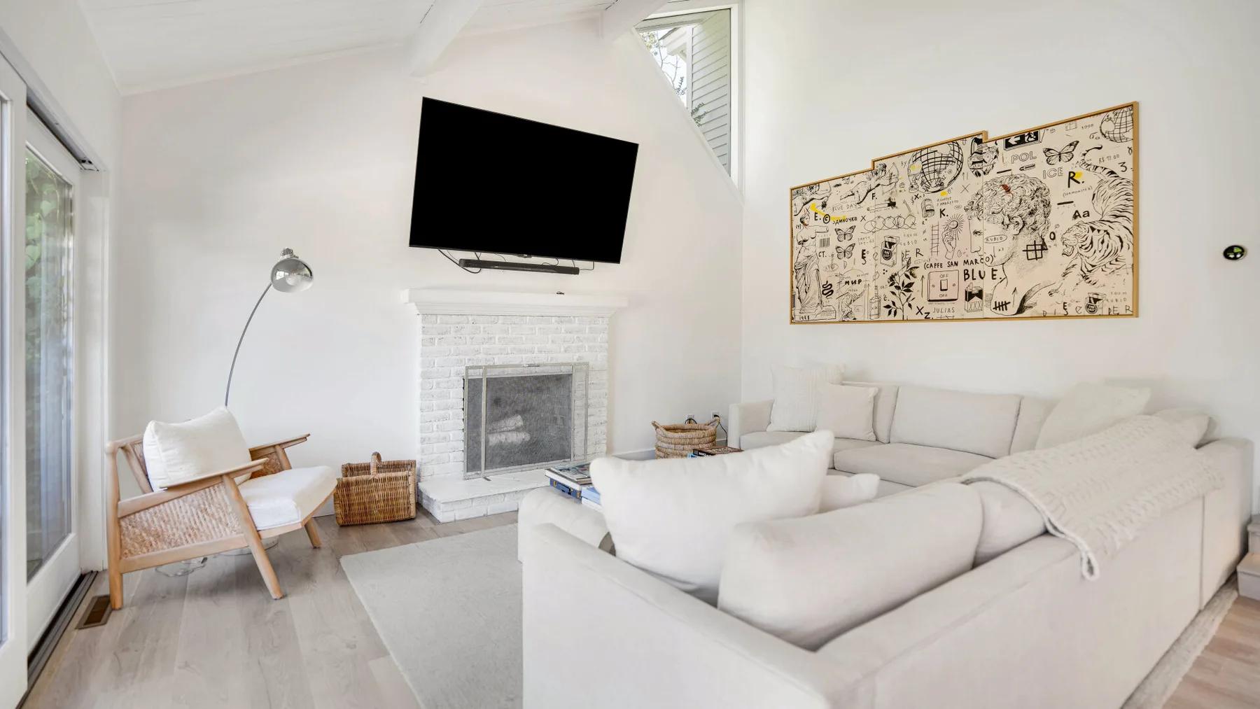 Una sala luminosa con una amplia zona de asientos y una chimenea.