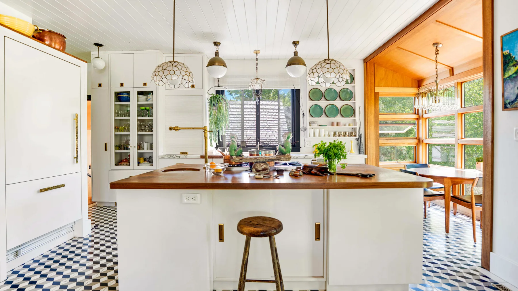 Una cocina luminosa con una isla central y suelo de cuadros.