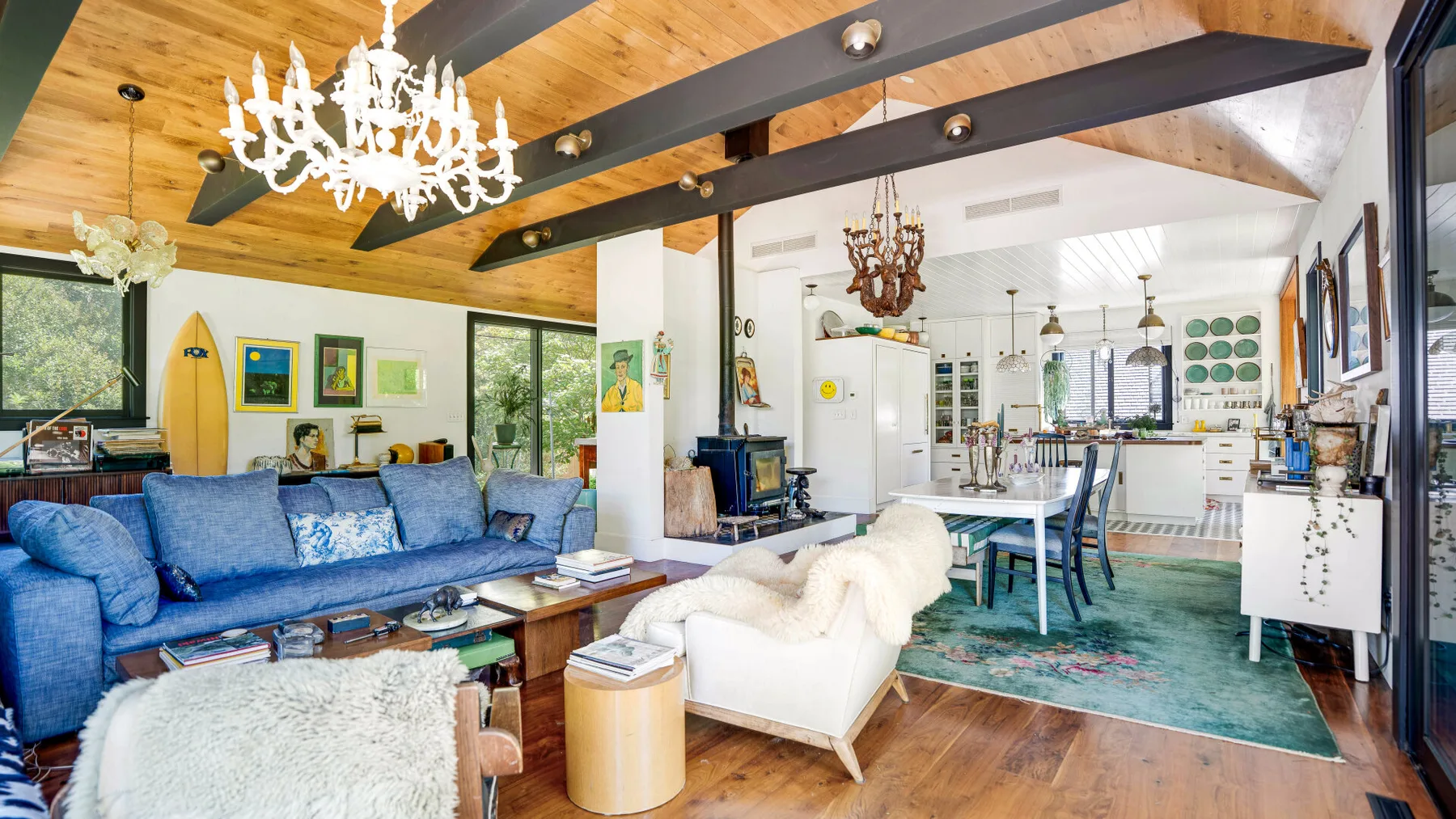 Una sala de estar y cocina de planta abierta con asientos azules y una mesa de comedor.