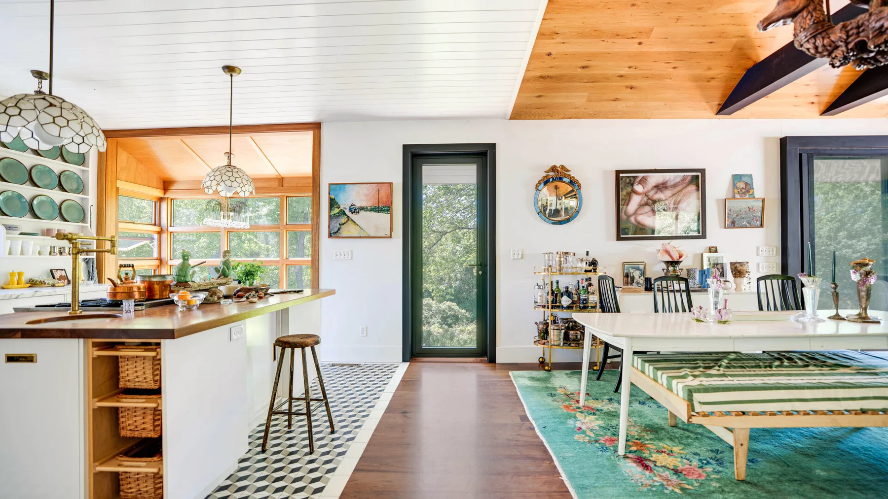 Una cocina abierta y comedor con una mesa larga y ventanales.