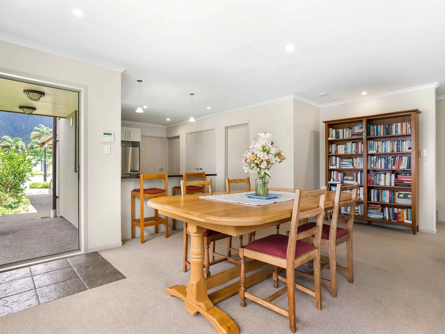 Un comedor con una mesa y sillas en Sue's Holiday Home - Pauanui