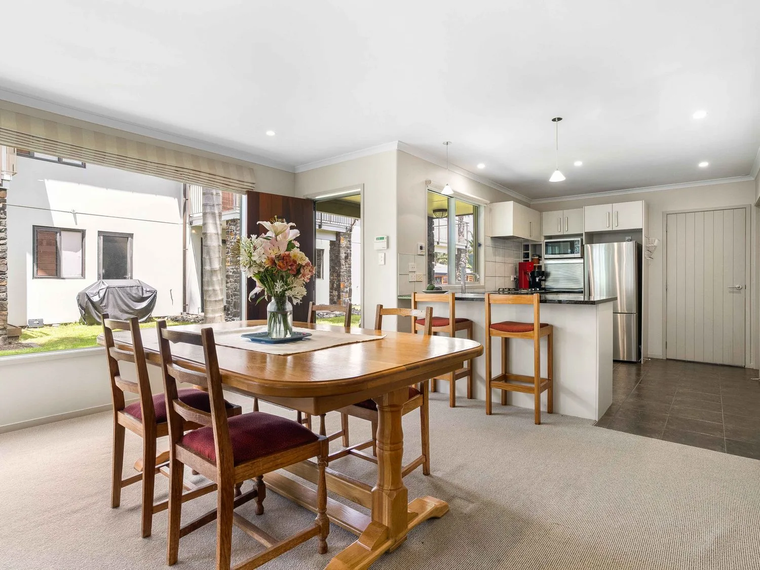 Un comedor con una mesa y sillas en Sue's Holiday Home - Pauanui Holiday Home, Pauanui