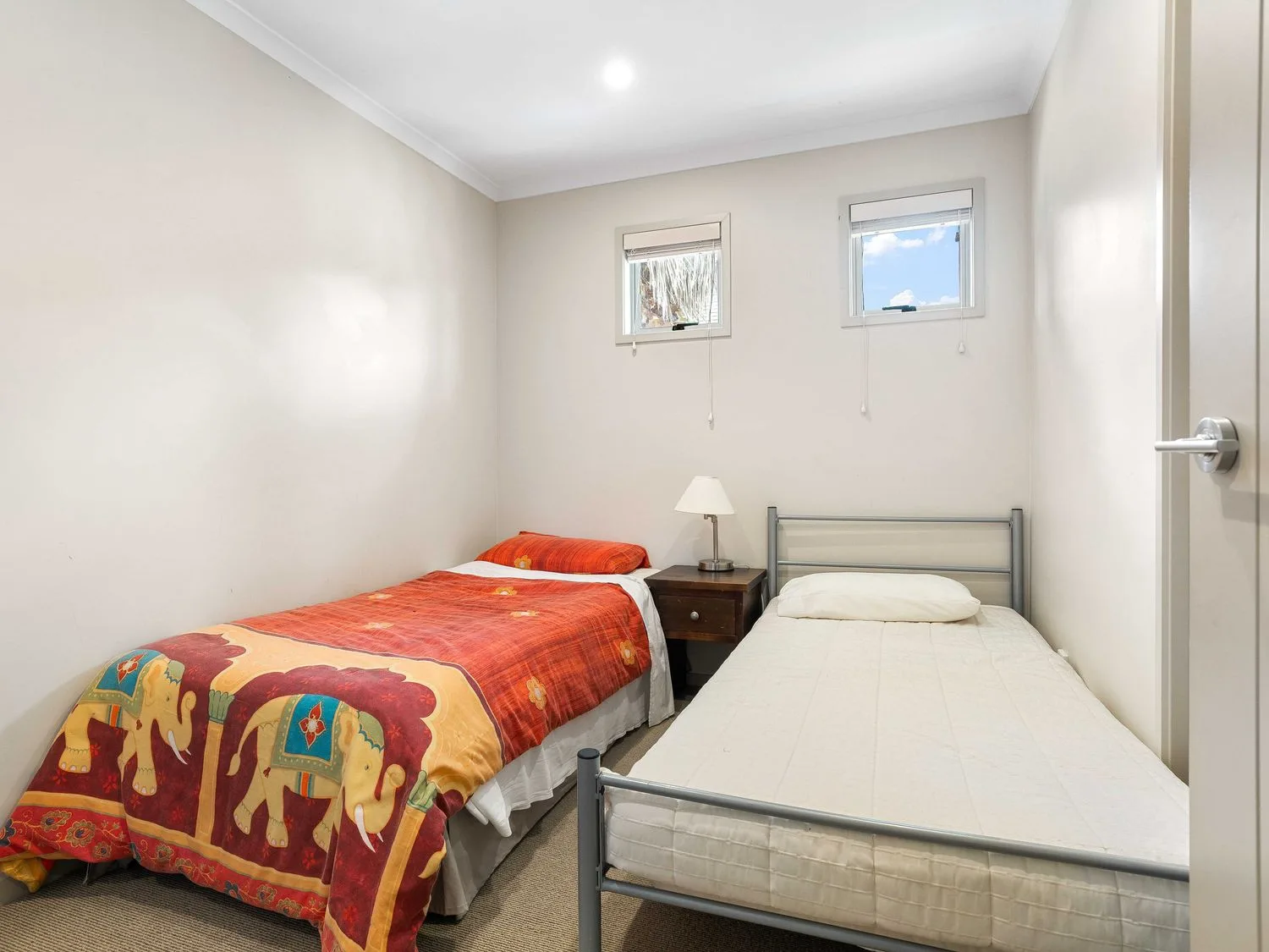 Un dormitorio con dos camas y una mesita de noche en Sue's Holiday Home - Pauanui