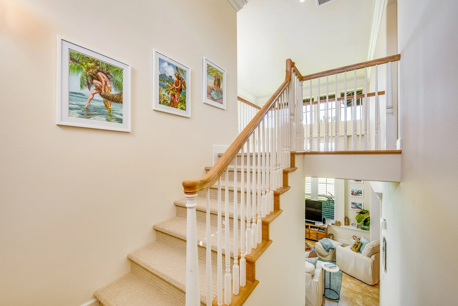 A carpeted staircase rises beside a bright living area.