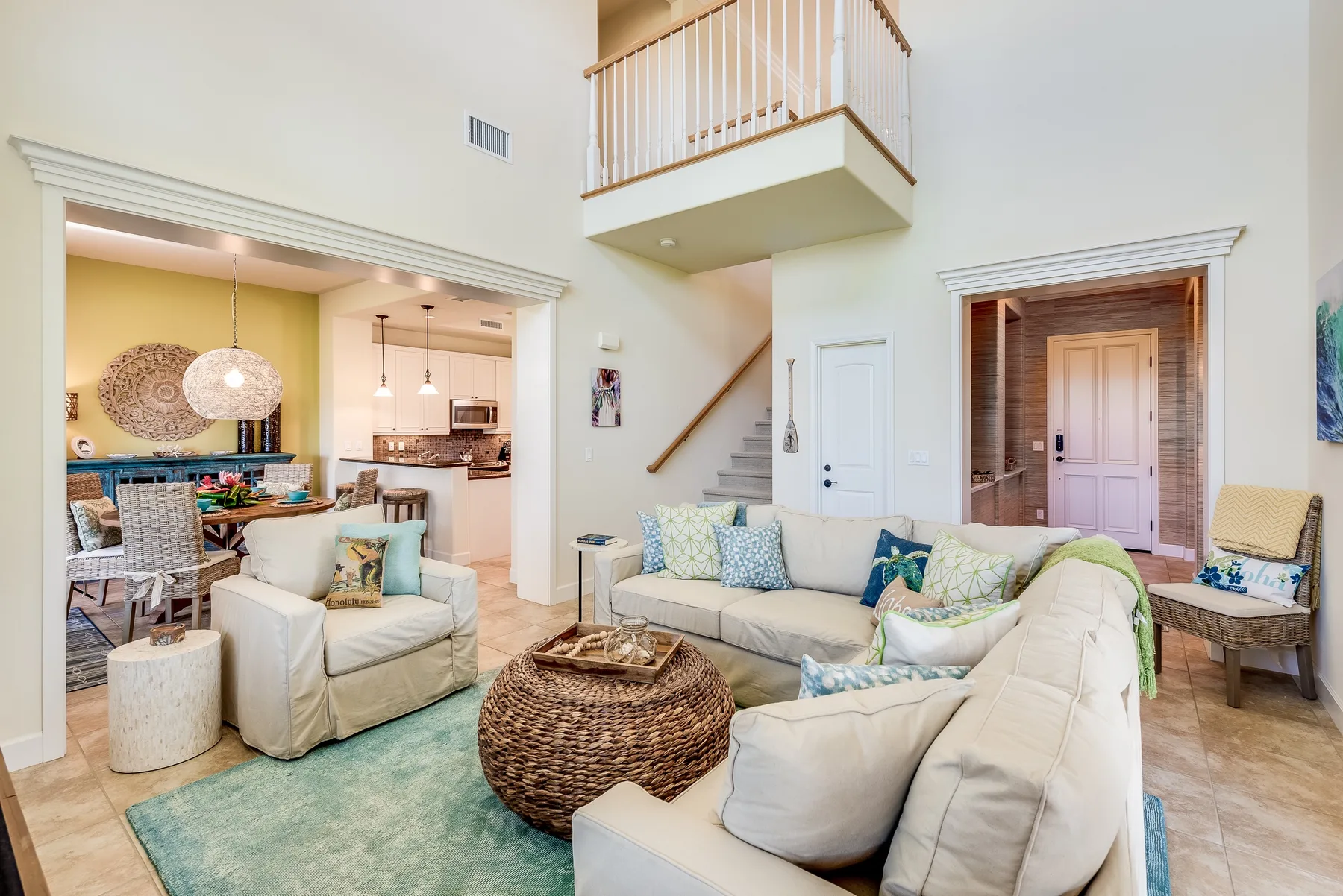 A bright living room with seating arranged around a woven coffee table.