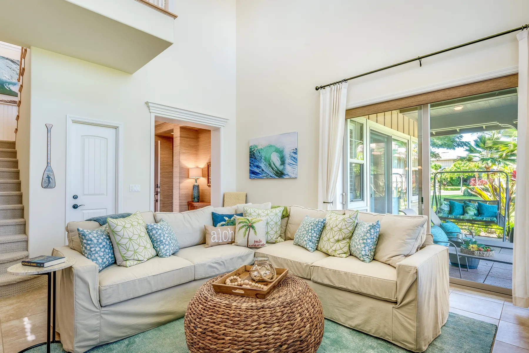 A bright living room with an L-shaped seating area beside large glass doors.