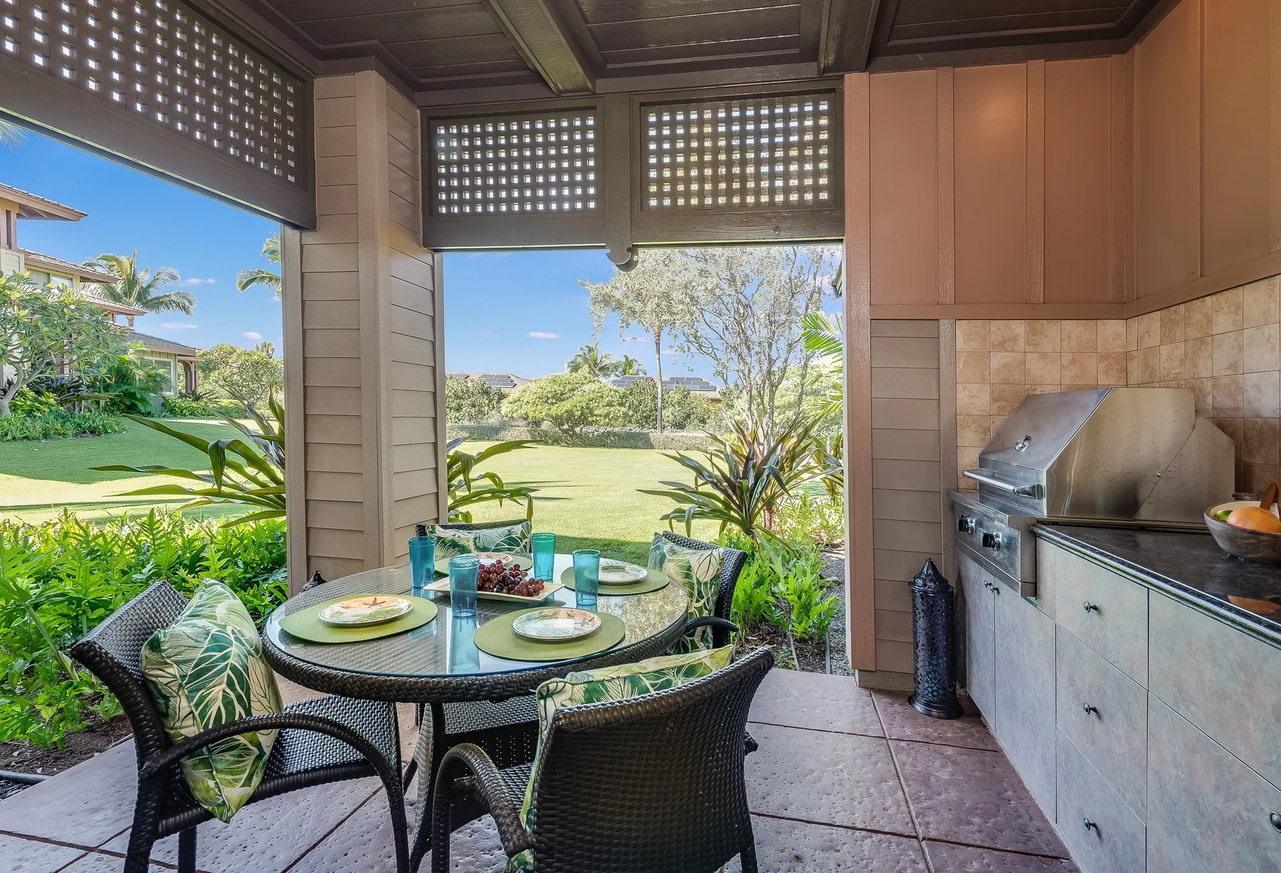 A covered patio dining area with a round table and garden views.
