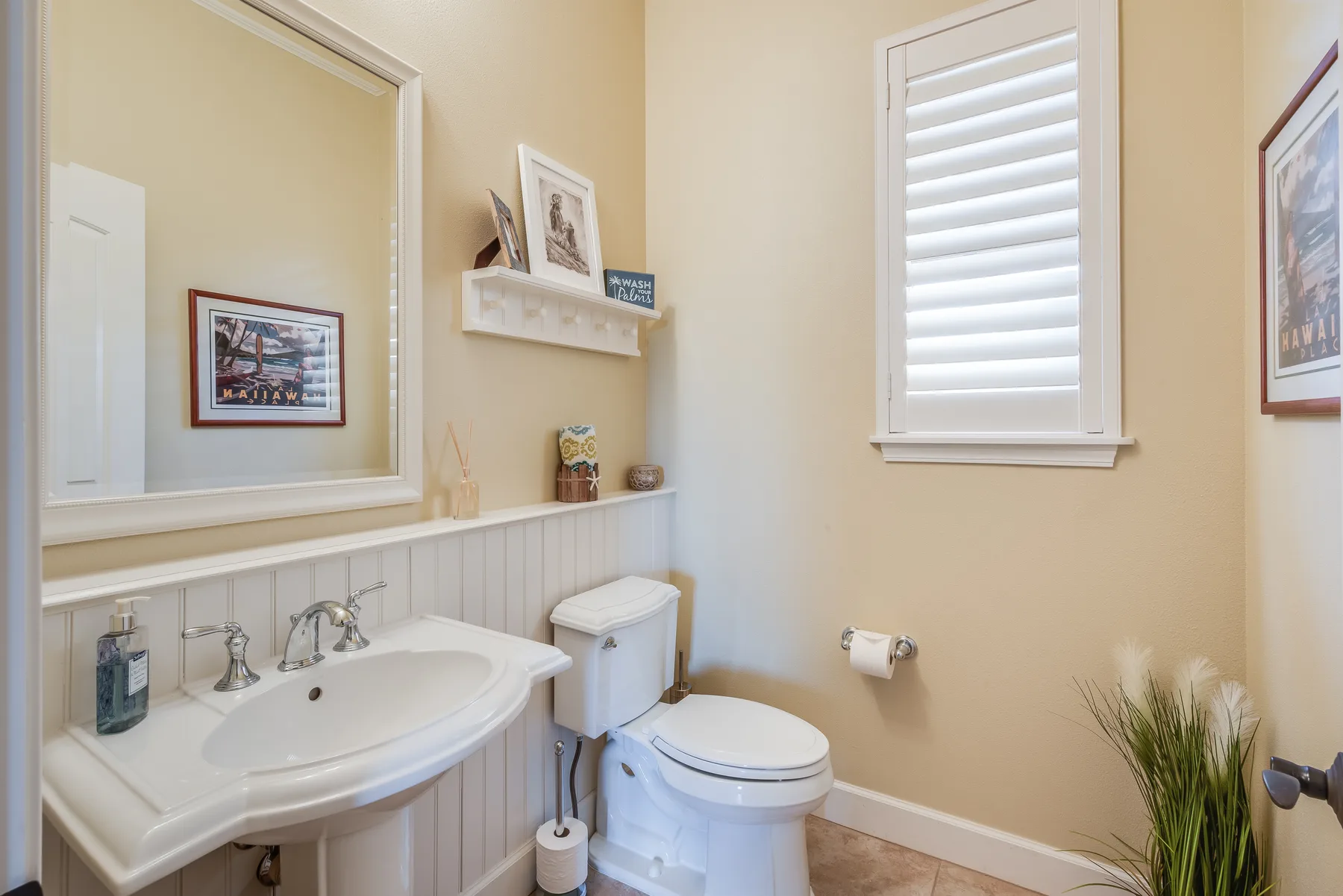 A bathroom with a sink, toilet, and shuttered window.