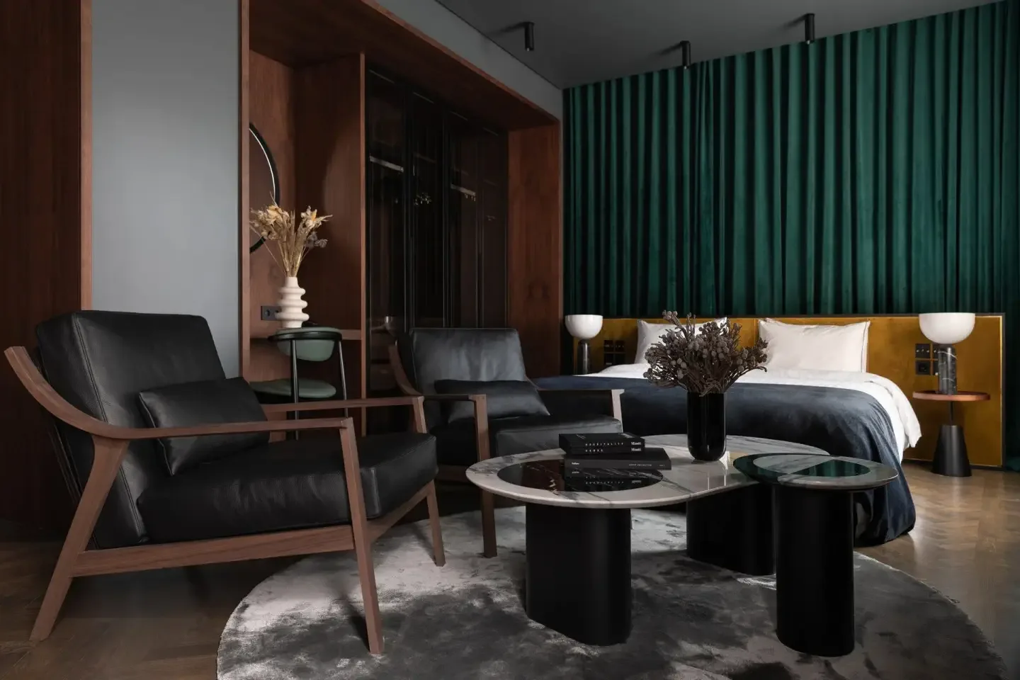 Suite with green fluted wall, lounge seating and king bed