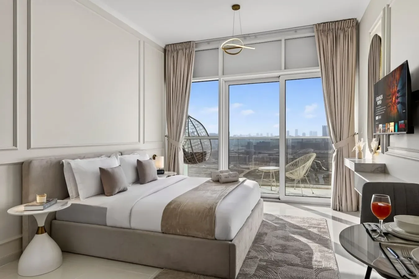 Un dormitorio con una cama grande junto a ventanales y cortinas.