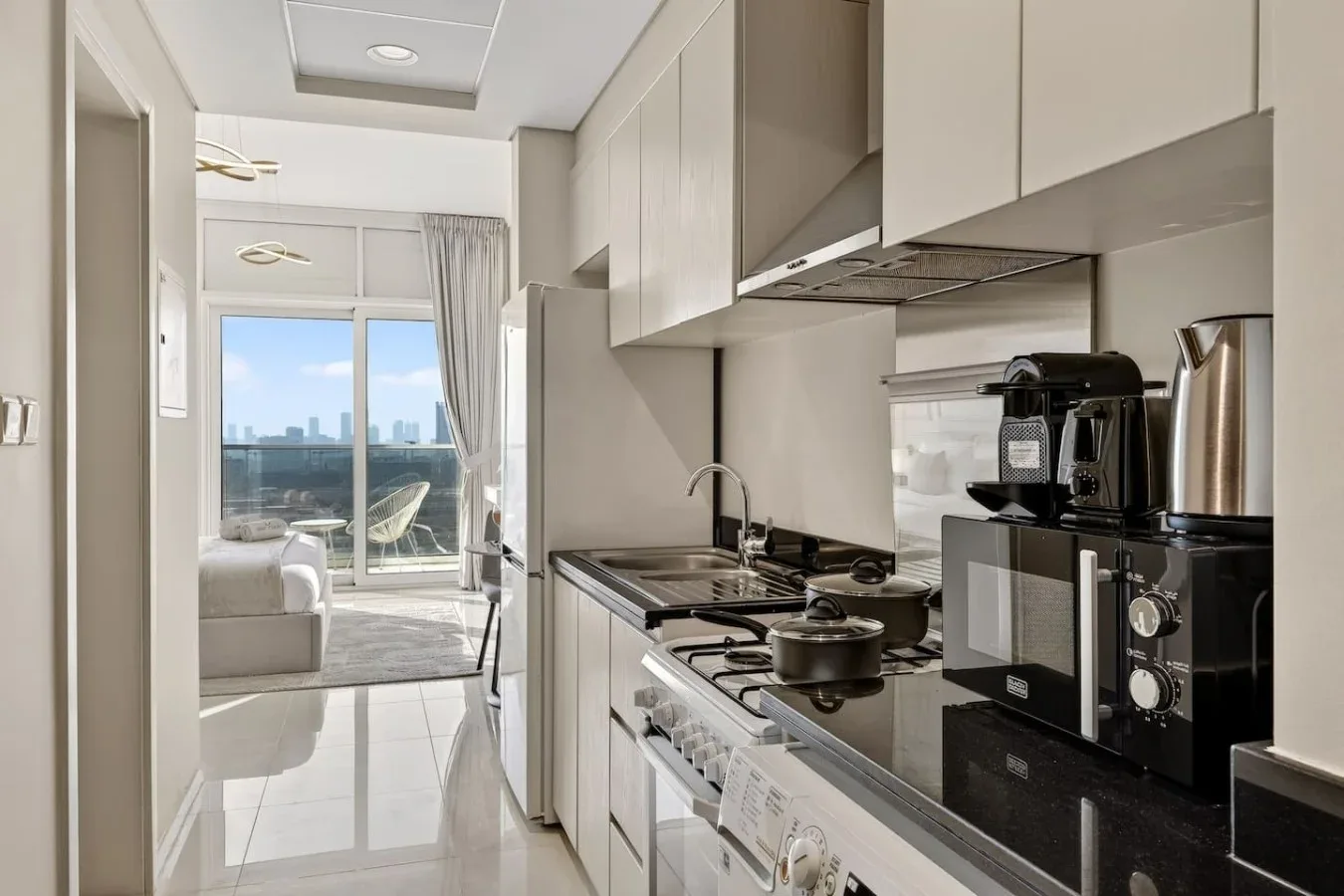 Una cocina moderna se abre a una sala luminosa con una ventana grande.