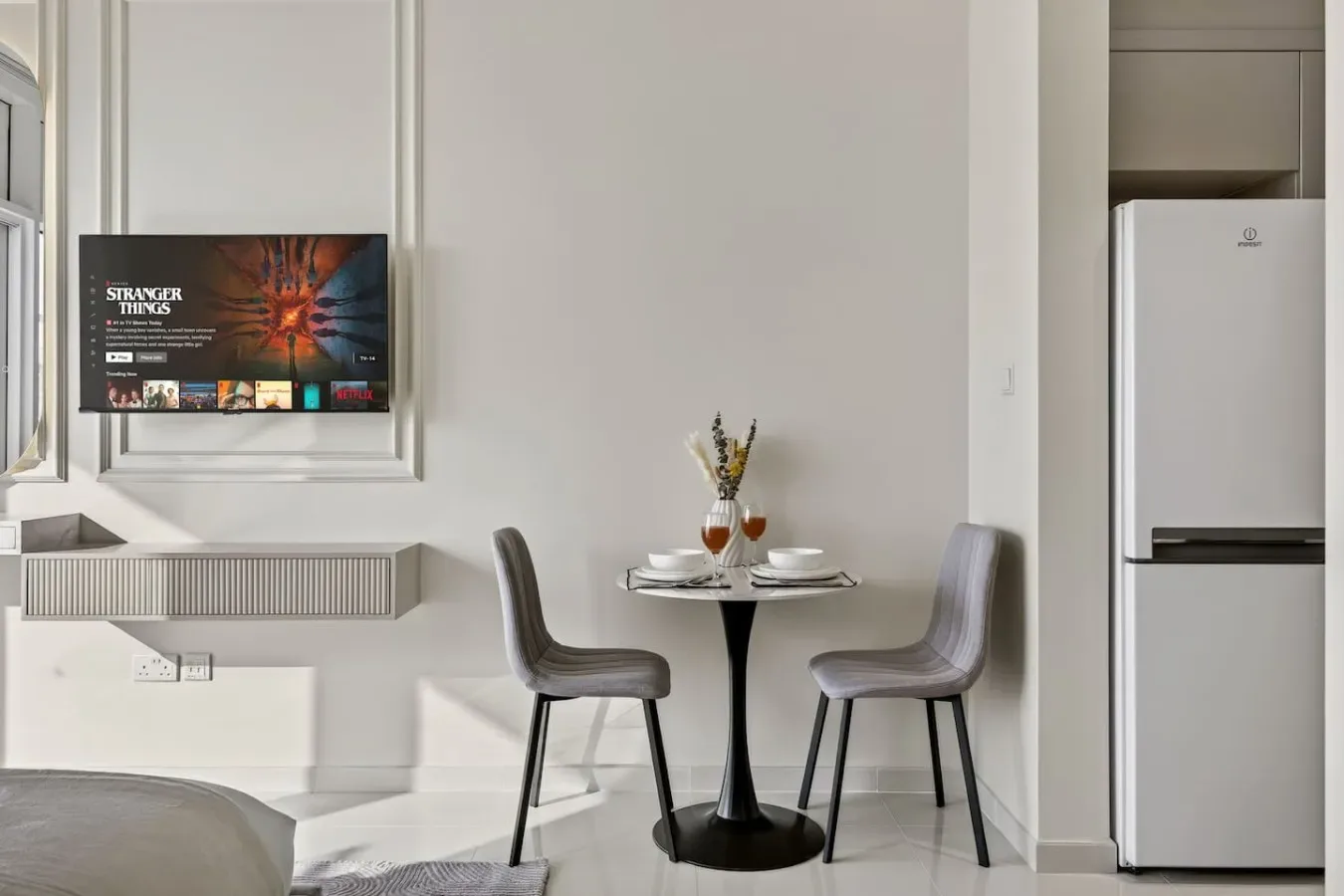 Una luminosa zona de comedor tiene una mesa pequeña junto a dos sillas.