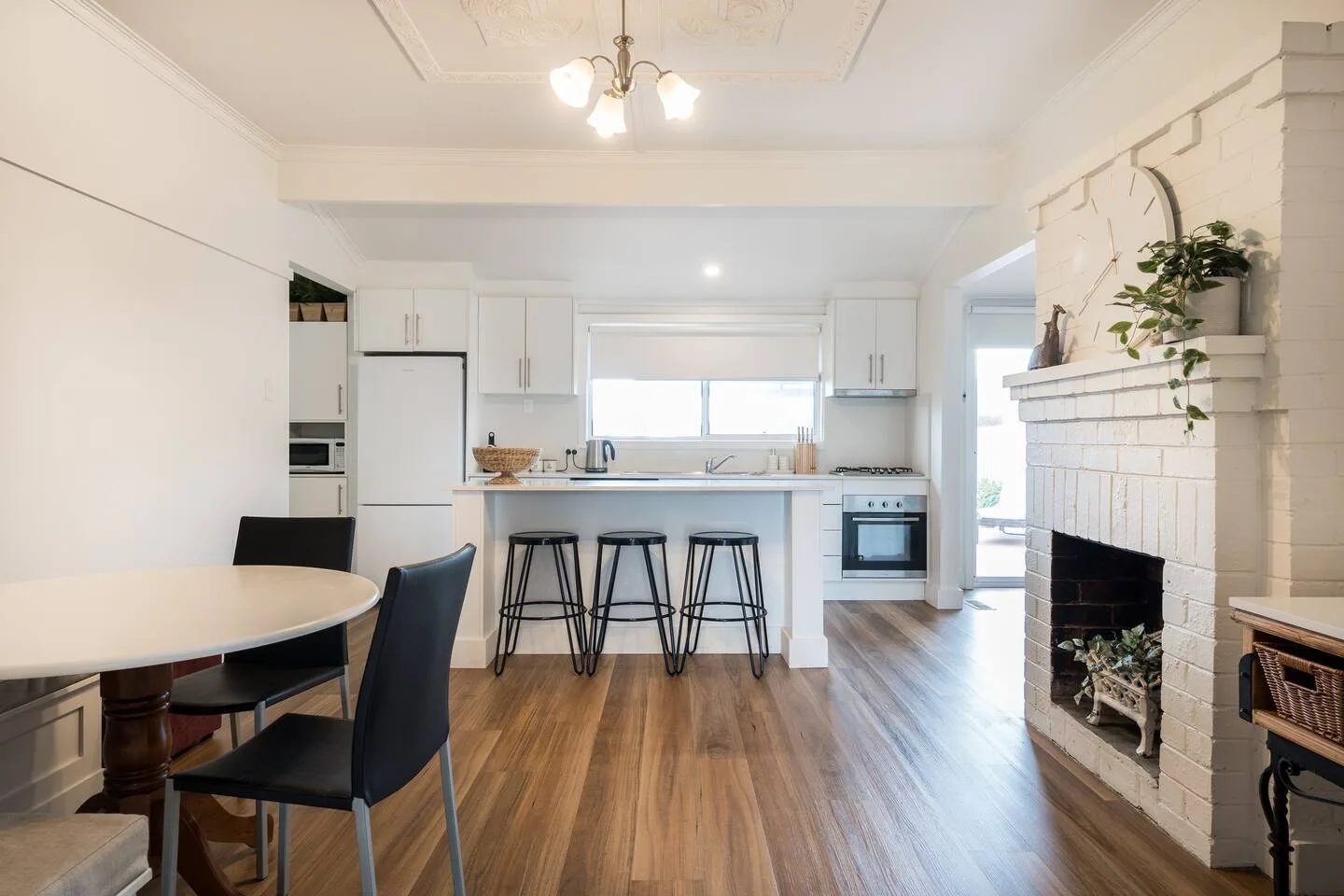 La zona de comedor y la cocina comparten un espacio abierto, con una chimenea junto a los asientos.