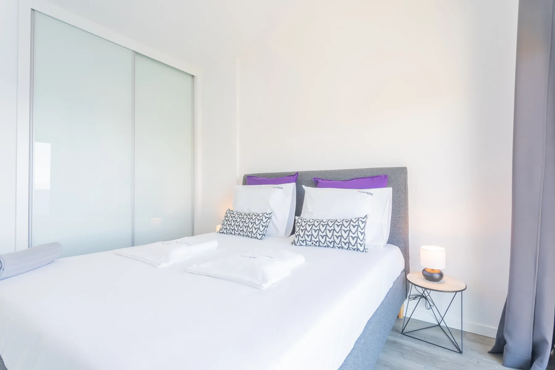Un dormitorio con una cama bien tendida y puertas corredizas de armario.