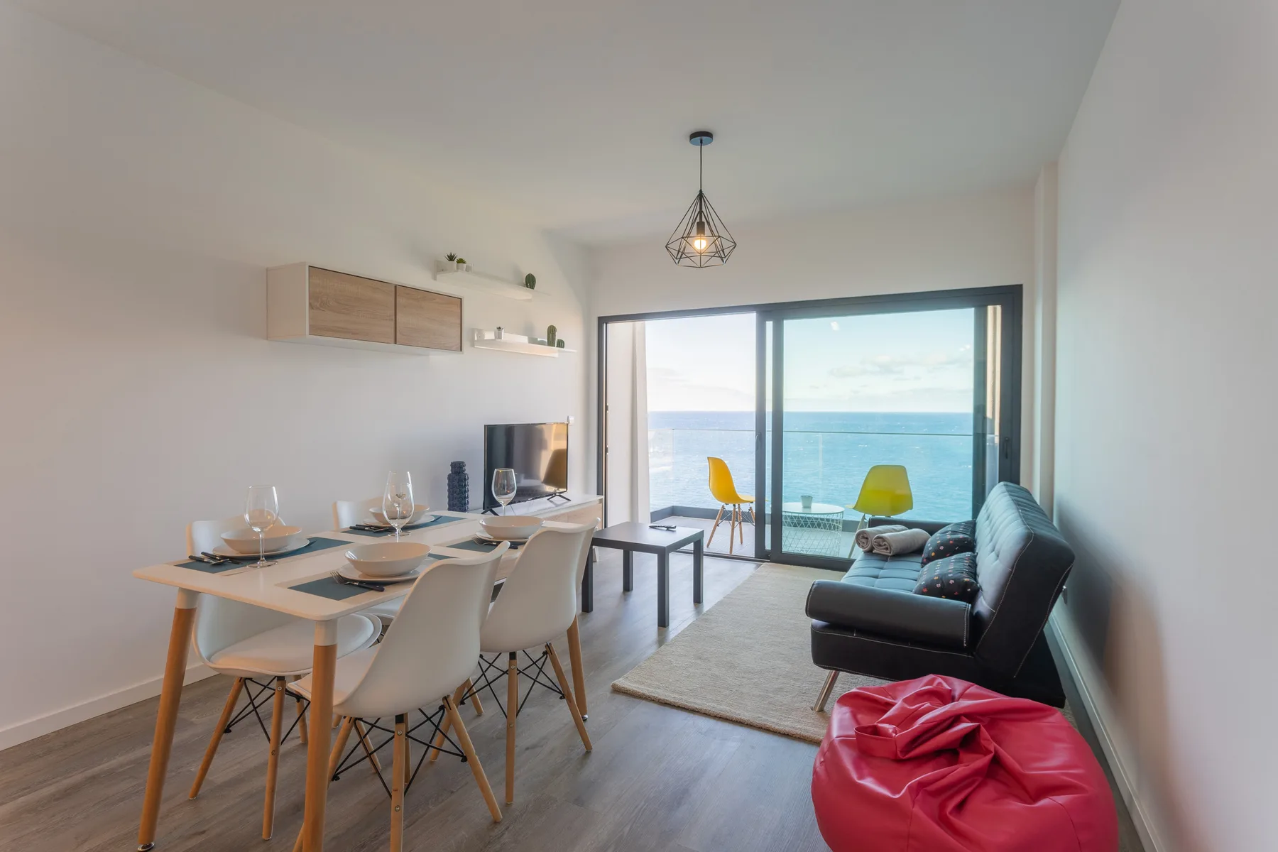 Una sala de estar y comedor se abre a un balcón con vistas al océano.