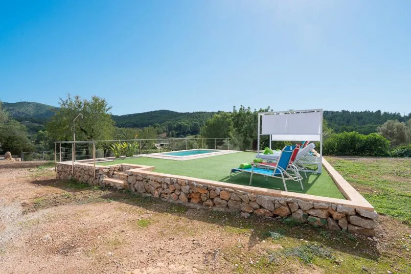 An outdoor pool area with lounge seating and a low stone border.