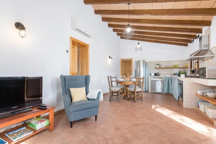 A combined living, dining, and kitchen area with a television and dining table.