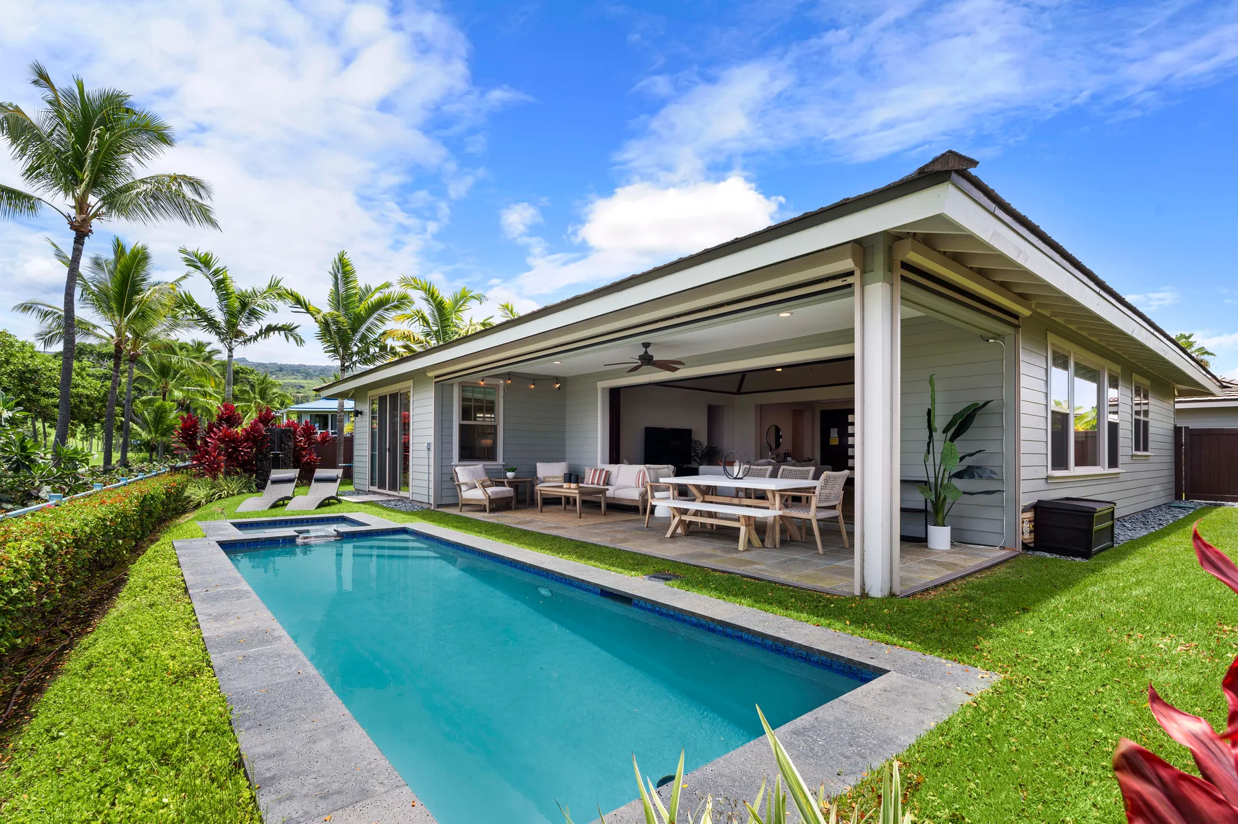 A swimming pool beside a single-story house with an open covered patio.