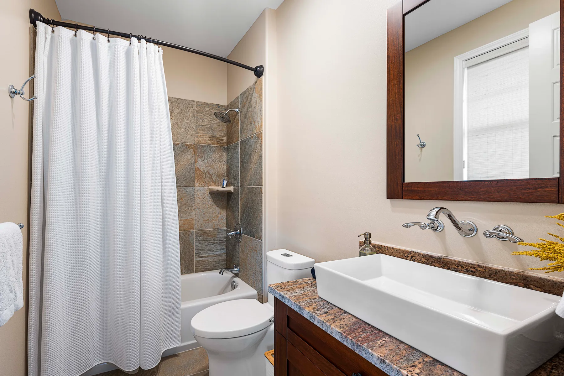 A bathroom with a shower, bathtub, toilet, and sink.