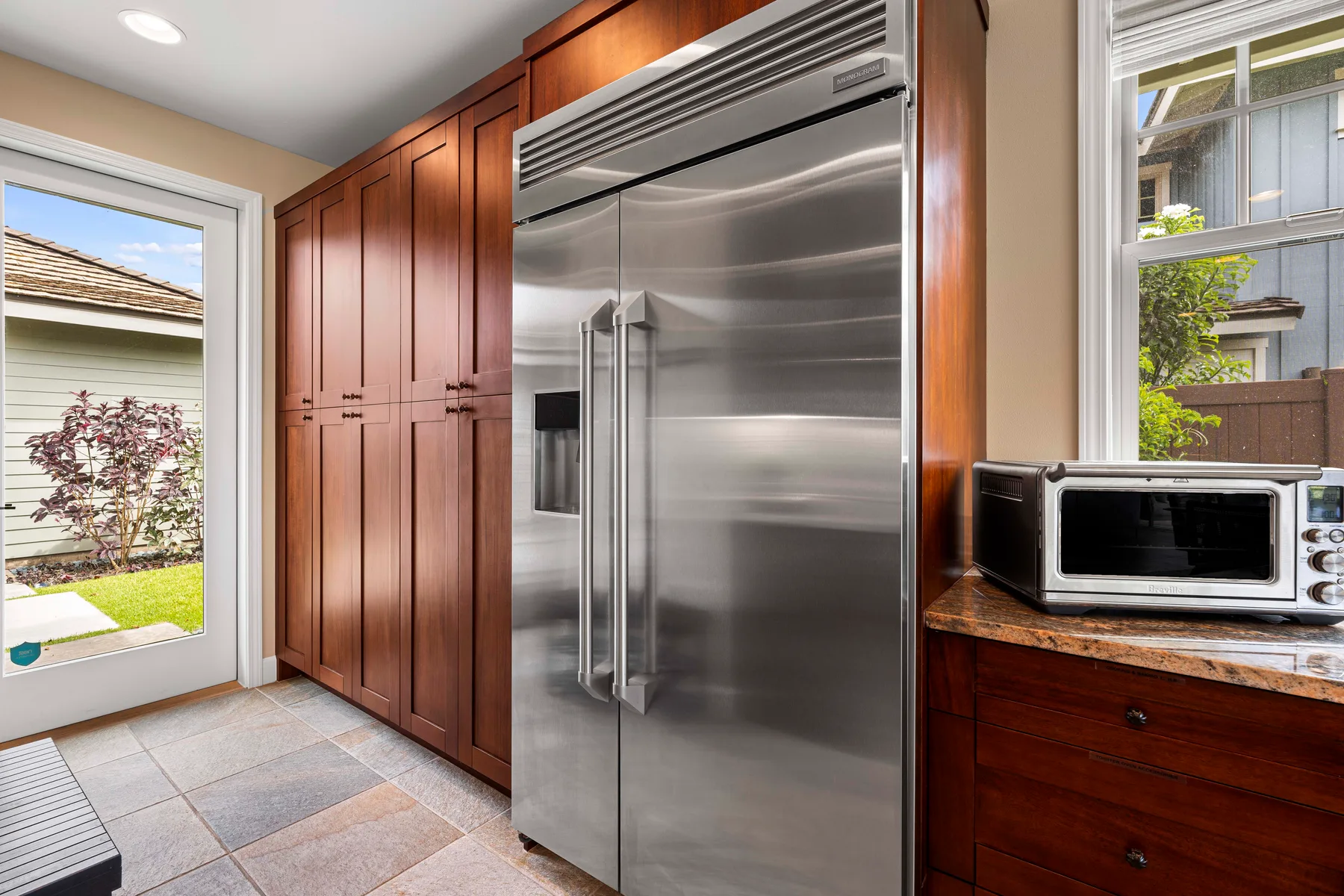 A kitchen with a stainless-steel refrigerator and wooden cabinets.
