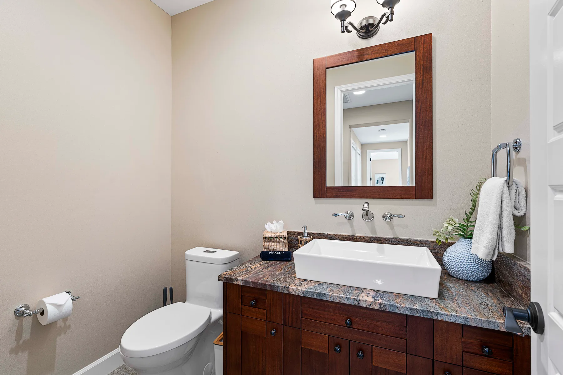 A bathroom with a sink, mirror, and toilet.