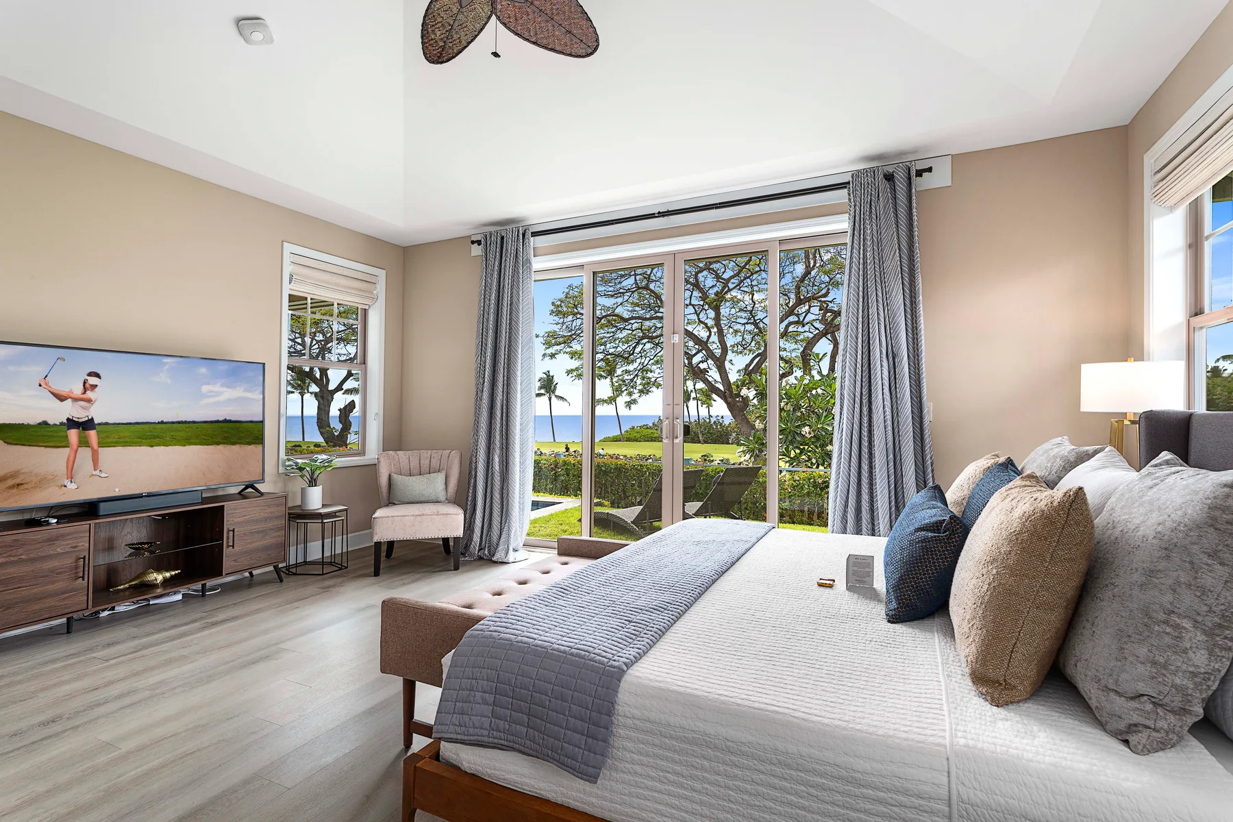 A bedroom with a bed facing sliding glass doors that open onto a garden view.
